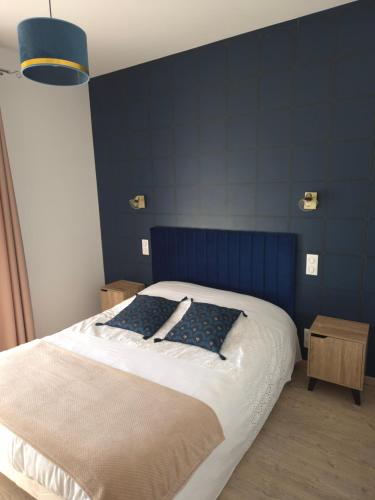 a bedroom with a bed with a blue wall at T2 Centre ville, Soulages, Amphithéâtre - WIFI clim balcon parking in Rodez