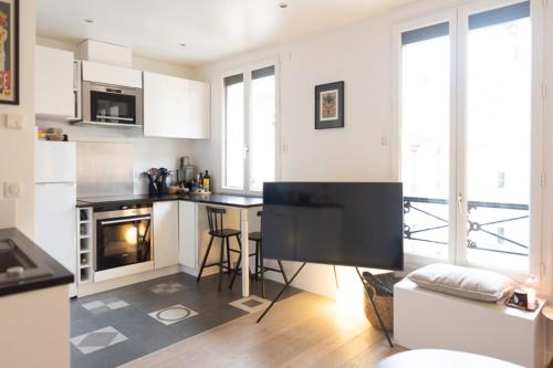 une cuisine avec des armoires blanches et un comptoir dans l'établissement Comfortable T2 apartment - Sacré Coeur view, à Paris
