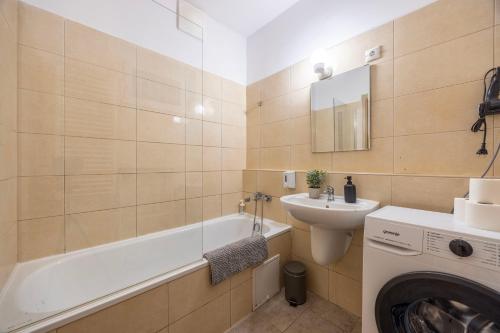 a bathroom with a sink and a washing machine at Cozy Sweet Hideaway Apartment in the Heart of Budapest in Budapest
