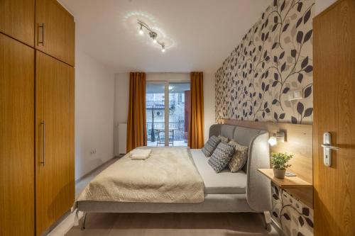a bedroom with a bed and a wall at Cozy Sweet Hideaway Apartment in the Heart of Budapest in Budapest