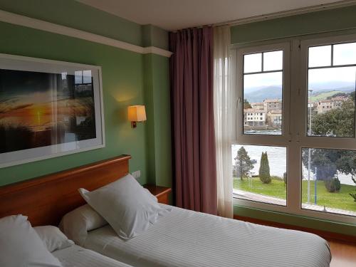 a hotel room with a bed and a window at Hotel Faro de San Vicente in San Vicente de la Barquera