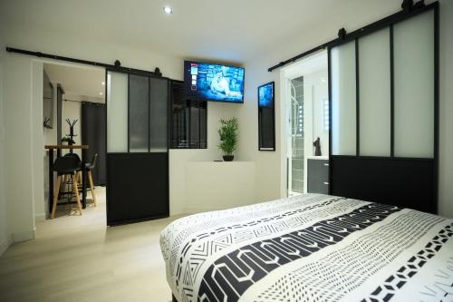 a bedroom with a large bed and a flat screen tv at Le Carolo Ducal in Charleville-Mézières