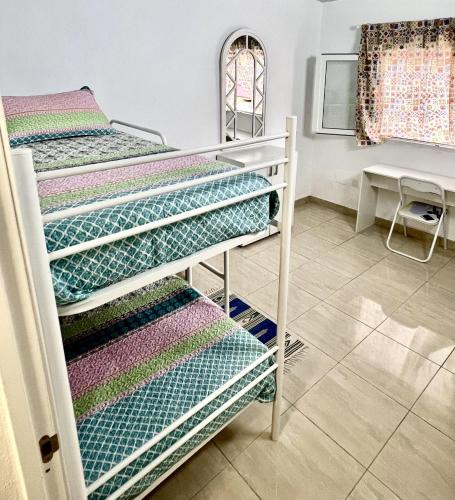 two bunk beds in a room with a table at Buenavista - CHC - Mar Azul in Buenavista del Norte