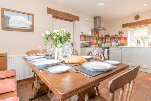 a dining room with a wooden table and chairs at Perthi-Uchaf in Cwm-y-glo