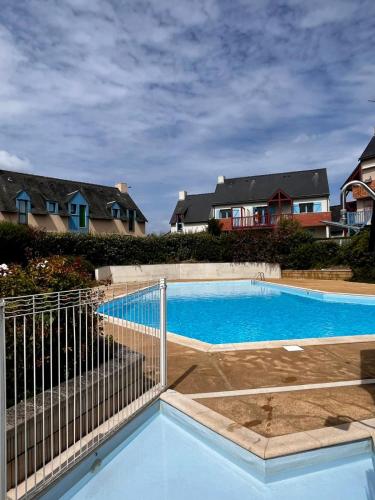 une piscine avec une clôture et quelques maisons dans l'établissement villa rotheneuf, à Saint-Malo