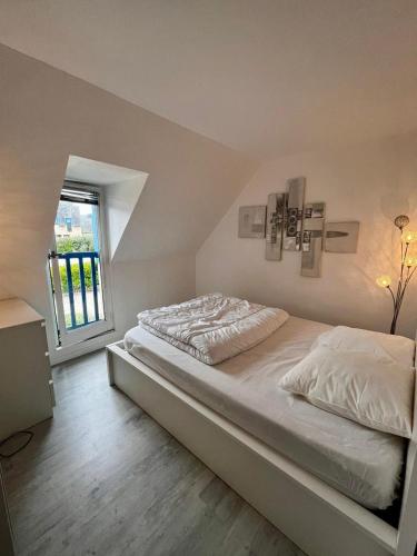 une chambre avec un grand lit avec une fenêtre dans l'établissement villa rotheneuf, à Saint-Malo