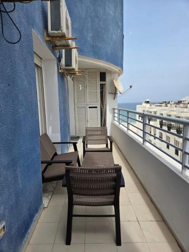a balcony with chairs and tables on a building at Luxurious 2 bedroom apartment in Sousse