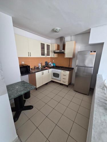 a kitchen with white cabinets and a stainless steel refrigerator at Luxurious 2 bedroom apartment in Sousse