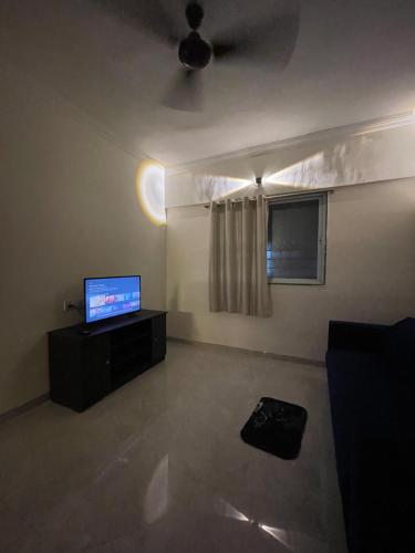 a living room with a flat screen tv and a couch at Budget Nest Baner,Wakad,Balewadi,Pune in Pune