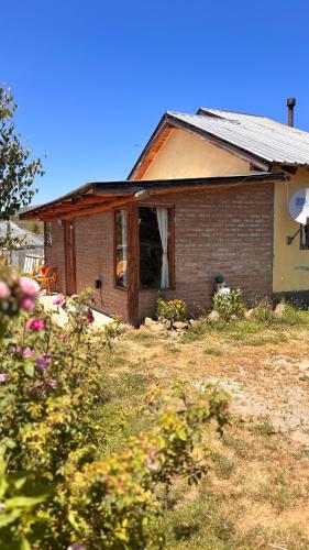 a small brick house with a window in a yard at Departamento Río Blanco in Cholila