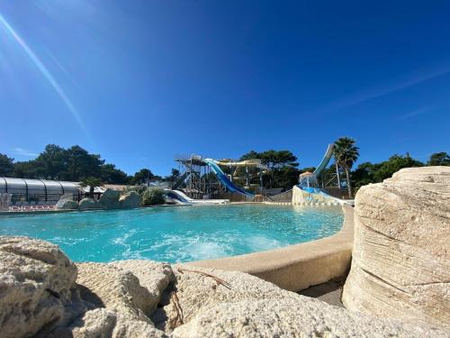 un parc aquatique avec un toboggan et des toboggans dans l'établissement Mobile home in 5-star camping, à Montalivet-les-Bains