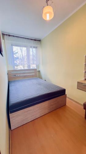 a bed in a room with a window at Wyzwolenia Street in Konin