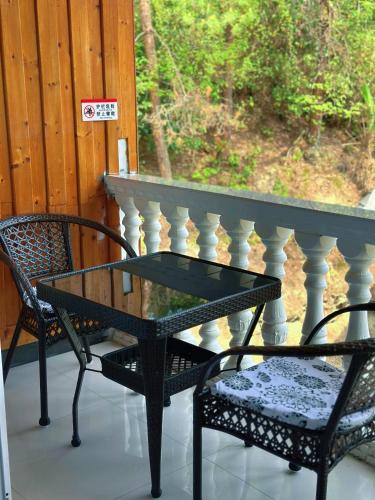 a glass table and two chairs on a porch at Tongfu Inn(In the National Park) in Zhangjiajie