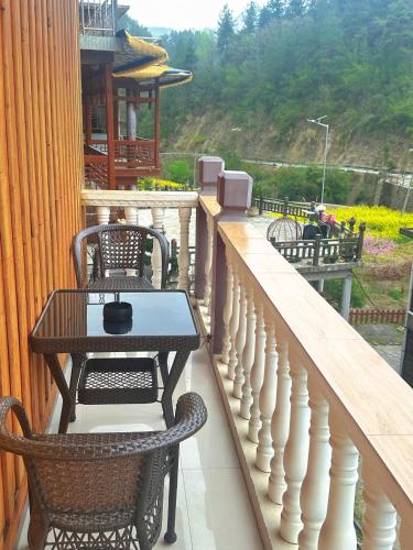 a table and chairs on a balcony with a table at Tongfu Inn(In the National Park) in Zhangjiajie