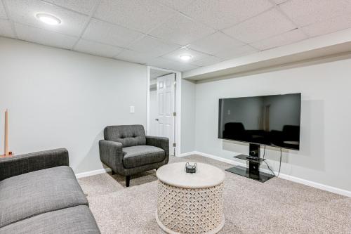 a living room with a couch and a tv and chairs at 3 Mi to Dtwn Saginaw Spacious and Updated Home! in Saginaw