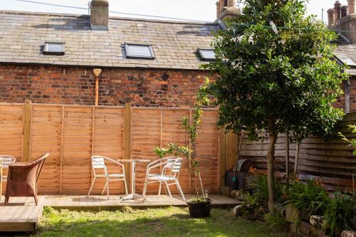 a garden with chairs and a table and a fence at Half Moon House - Timeless Charm with Sea Views in Scarborough