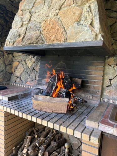 a brick fireplace with a fire in it at Casa vistas al mar con piscina y barbacoa in Benicàssim