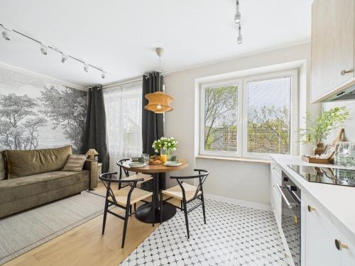 Una cocina y una sala de estar con mesa y sillas. en ApartamentySnu, Bema, en Radom