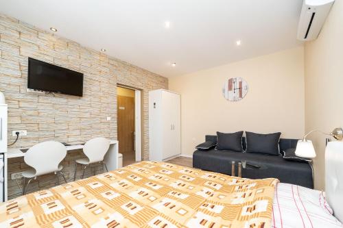 a bedroom with a king sized bed and a couch at Apartments Bracic Spa in Sukošan