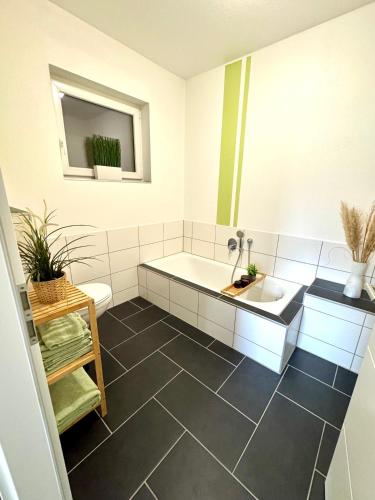 a bathroom with a tub and a toilet and a sink at Ferienwohnung Enders in Dichtelbach