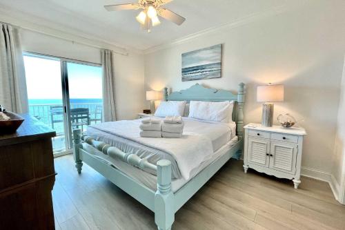 a bedroom with a blue bed and a balcony at Crystal Shores1006 condo in Gulf Shores