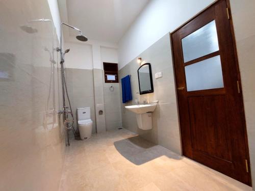 a bathroom with a shower and a sink and a toilet at Y&Y villa in Narigama