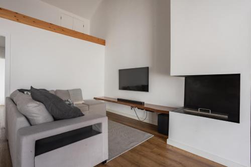 a living room with a couch and a flat screen tv at São Jorge Holiday Homes in Velas