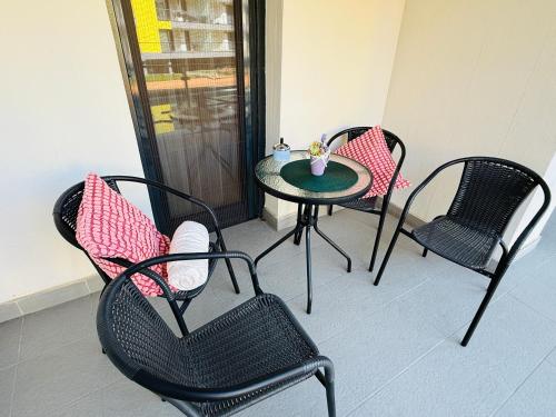 eine Terrasse mit 3 Stühlen, einem Tisch und einem Tisch in der Unterkunft Casa Romana 2 Siófok apartman in Siófok