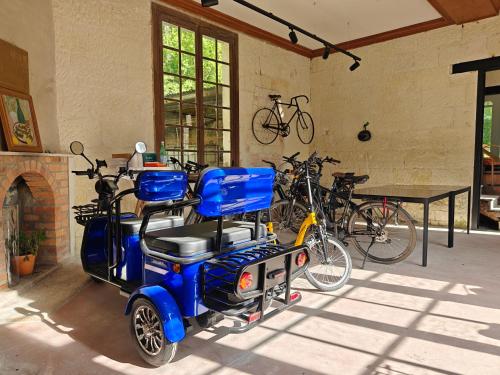 a blue mobility scooter parked in a room with bikes at Château de Vallagon in Montrichard