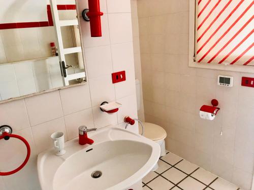 a bathroom with a white sink and a toilet at Casa Belvedere in Diano San Pietro