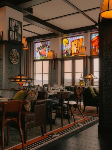 a restaurant with tables and chairs and stained glass windows at Maison Heler Metz, Curio Collection By Hilton in Metz