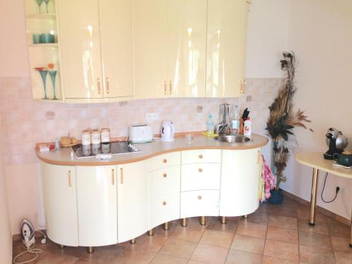 a kitchen with white cabinets and a sink at Apartament in highlander style with view on Giewont & Tatra Mountain in Zakopane