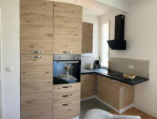 une cuisine avec une grande armoire en bois et un coffre à poisson dans l'établissement T2 Ajaccio - A deux pas de la plage, à Ajaccio