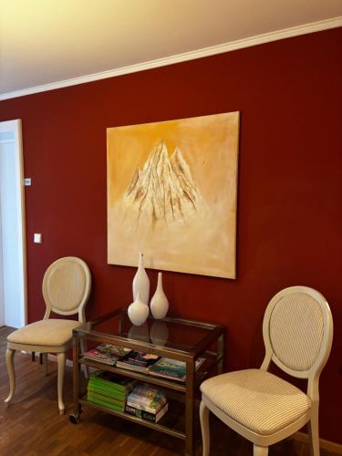 two chairs and a table in a living room with a painting at Landgasthof Zum Engel in Angelbachtal