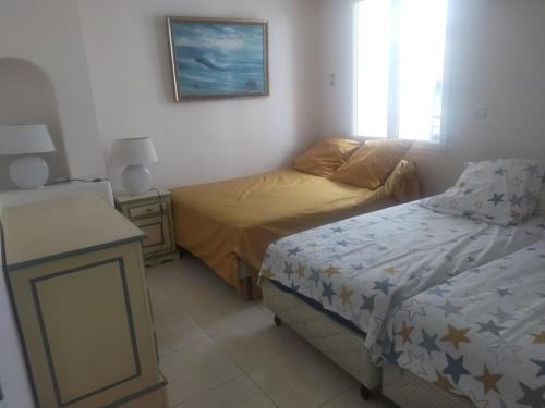 - une chambre avec deux lits et une table de nuit avec un couvre-lit dans l'établissement Splendide appartement face Croisette - SOU3528, à Cannes