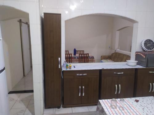 a kitchen with wooden cabinets and a large mirror at Casa Praia com piscina Itanhaem in Itanhaém