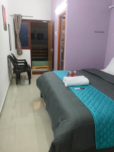 a bedroom with a bed with a blue blanket on it at Rudhraksh Comfort Stay in Tiruvannāmalai