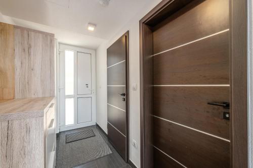 a hallway with a wooden door and a door at Dreamhouse 1 Apartment - by myNests in Gröbming