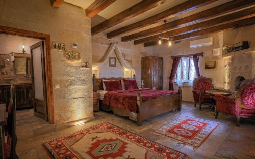 Un dormitorio con una cama y una mesa y sillas. en Maccan Cave Hotel, en Göreme