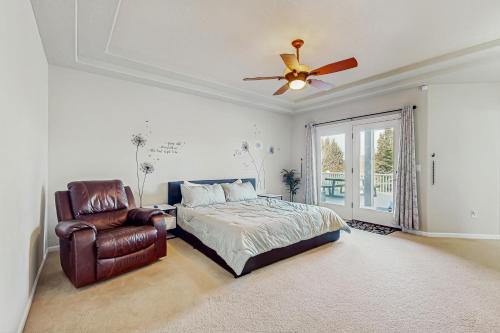 a bedroom with a bed and a chair and a ceiling fan at Whispering Pines Haven in Redmond