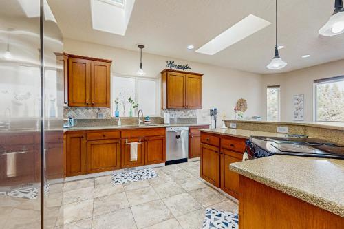 a large kitchen with wooden cabinets and stainless steel appliances at Whispering Pines Haven in Redmond