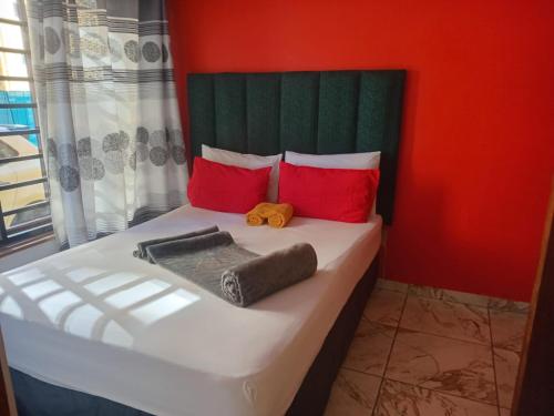 a bedroom with a bed with red and green at Neo & Ruks rooms parow 2 in Avondale