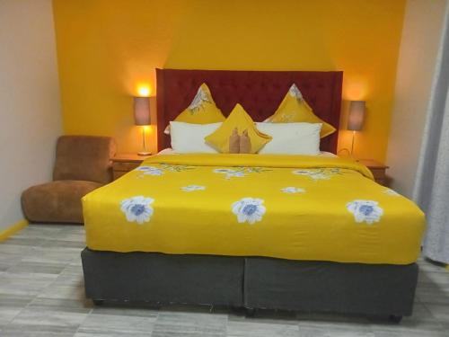 a large yellow bed in a hotel room at Neo & Ruks rooms parow 2 in Avondale