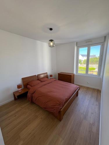 une chambre avec un grand lit et une fenêtre dans l'établissement Cozy apartment, à Plouharnel