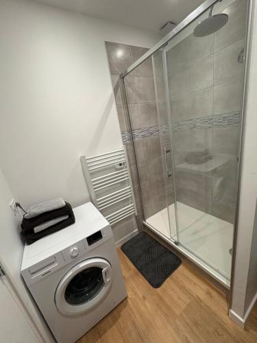 une machine à laver dans une salle de bain avec douche dans l'établissement Cozy apartment, à Plouharnel
