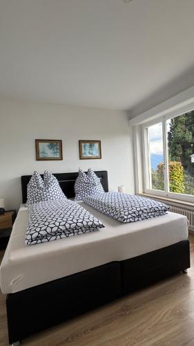 a large bed in a bedroom with a large window at Casa Angela in Orselina