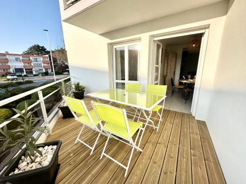 un balcon avec une table et des chaises sur une terrasse dans l'établissement T2 Hyper Cocon Terrasses - Parking, à Larmor-Plage