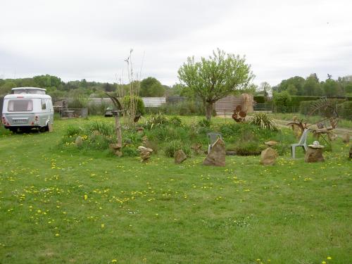 un jardin avec des rochers dans l'herbe dans un champ dans l'établissement Chez Didier Emplacements tentes et Camping cars, à Saint-Pavace