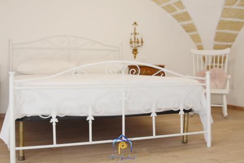 a bedroom with a white bed and a chair at Mescia Alba x AP Apartment in Gallipoli