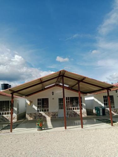 a large wooden pavilion in front of a building at Cabañas hotel COLONIA SAN MIGUEL in Paipa